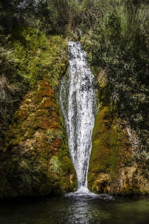Cascada entre paredes cubiertas de musgo
